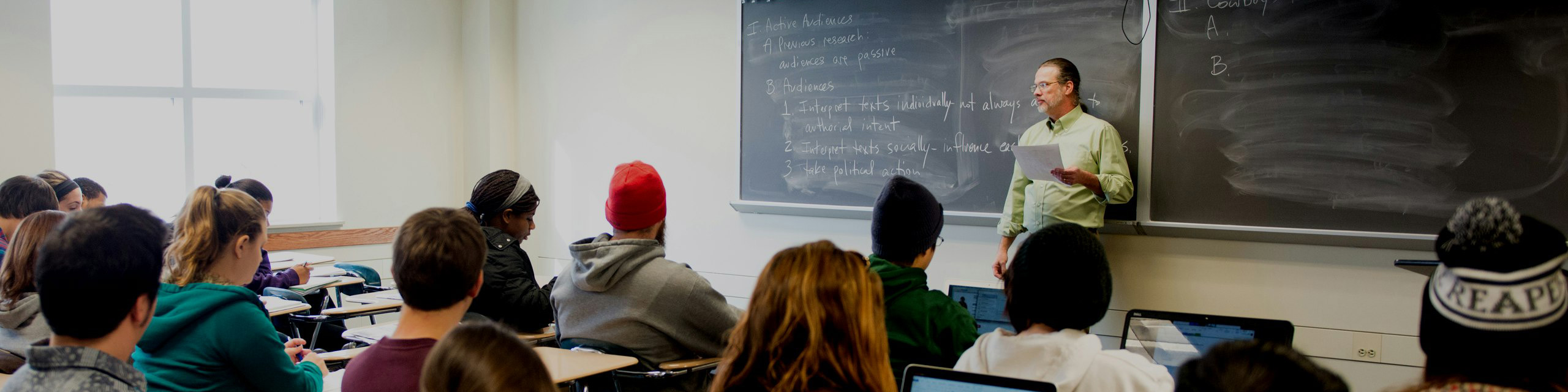 Teacher in a full classroom giving a lecture