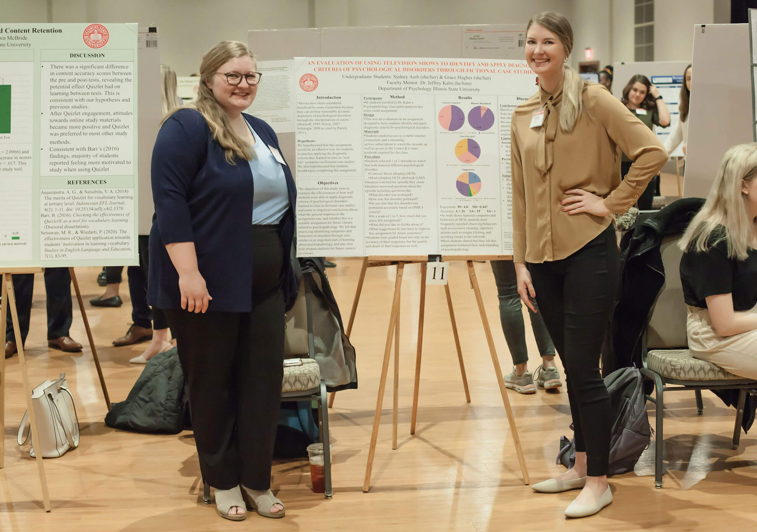 Two students displaying their research poster.